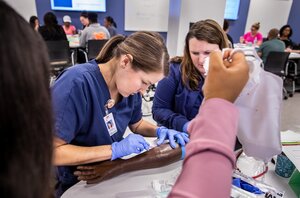 nurse is training on how to put in an IV